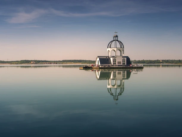 Plovoucí kostel VINETA uprostřed jezera Störmthal v Lipsku Neuseenland se při západu slunce odráží ve vodě, Lipsko, výletní cíl