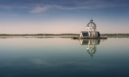 Plovoucí kostel VINETA uprostřed jezera Störmthaler See v oblasti Leipzig Neuseenland se při západu slunce odráží ve vodě, region Lipsko, výletní cíl
