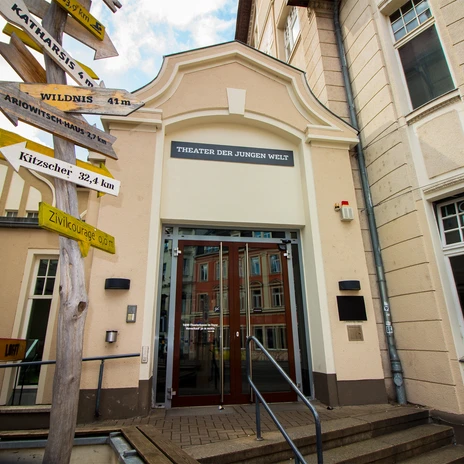 Pohled na vchod do Theater der Jungen Welt s různými nápisy vlevo, kultura, činohra, divadlo, volný čas.
