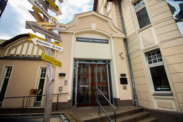 Teatr Młodego Świata w Lipsku - Kultura w Lipsku Widok na wejście do Theater der Jungen Welt z różnymi drogowskazami po lewej stronie, kultura, dramat, teatr, czas wolny