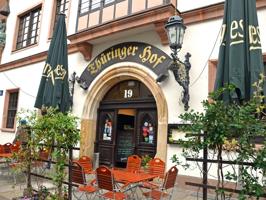 Thüringer Hof - Gastronomie in Leipzig Blick auf den Eingang zum Restaurant Thüringer Hof und den dazugehörigen Freisitz in der BurgstraßePohled na vstup do restaurace Thüringer Hof a její venkovní posezení na ulici BurgstraßeView of the entrance to the Thüringer Hof restaurant with its outdoor seating area on BurgstrasseVue sur l’entrée du restaurant Thüringer Hof et sa terrasse de la rue BurgstraßeWidok na wejście do restauracji Thüringer Hof i jej pomieszczenia zewnętrzne na świeżym powietrzu przy ul. Burgstraße