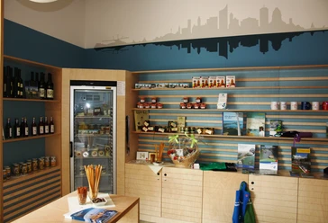 Tourist-Information Leipziger Neuseenland in Markkleeberg - Besucherberatung und Service Das Bild zeigt die mit regionalen Produkten und Souvenirs befüllten Regale in der Tourist-Information des Leipziger Neuseenland in Markkleeberg, die für Besucher zum Kauf bereitstehen, Leipzig Region