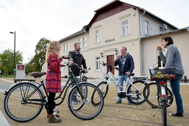 Czterech rowerzystów przed stacją kolejową Mügeln.