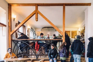 Vleischerei - Gastronomie in Leipzig Blick in das gut gefüllte Lokal und die zahlreichen Gäste an den Tischen und auf der Galerie, die auf veganes Fastfood warten, gastronomie, imbiss, freisitz
