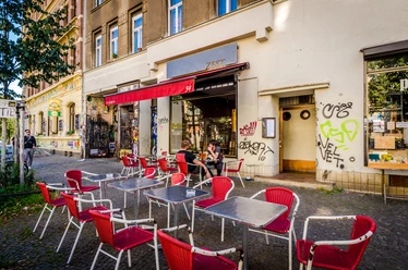 Zest - Gastronomie in Leipzig Blick auf die roten Stühle und die rote Markise im Freisitz vor dem Restaurant Zest, gastronomie, restaurant, kulinarik