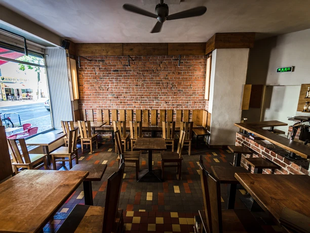 Zest - Gastronomie in Leipzig Blick in den Menschen-leeren Gastraum des Zest Leipzig; Einrichtung, Fenster, Stühle und Tische aus Holz