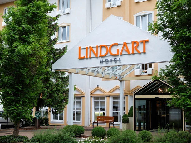 Allgemein_Lindgart-Hotel-Aussen_001.jpeg Fassade des Lindgart Hotels mit grünem Eingangsbereich und markantem Namensschild über der Tür.