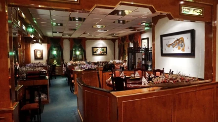Orchideengarten Ein asiatisches Restaurant mit Holzelementen, eleganten Sitzbereichen und exotischen Dekorationen.
