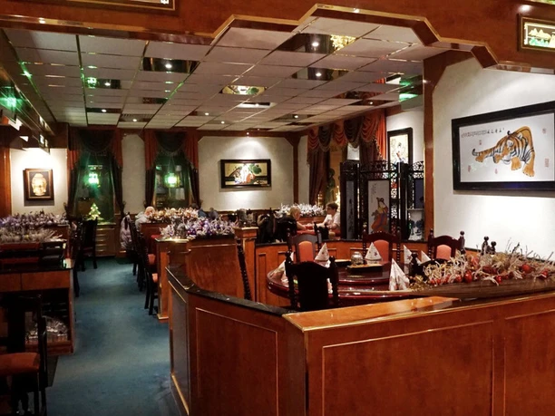 Orchideengarten Ein asiatisches Restaurant mit Holzelementen, eleganten Sitzbereichen und exotischen Dekorationen.