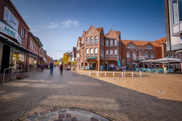 Haren (Ems) Innnenstadt Fußgängerzone in Haren mit rotem Klinker, Straßencafés, Geschäften und hellem Pflaster bei Sonnenschein.