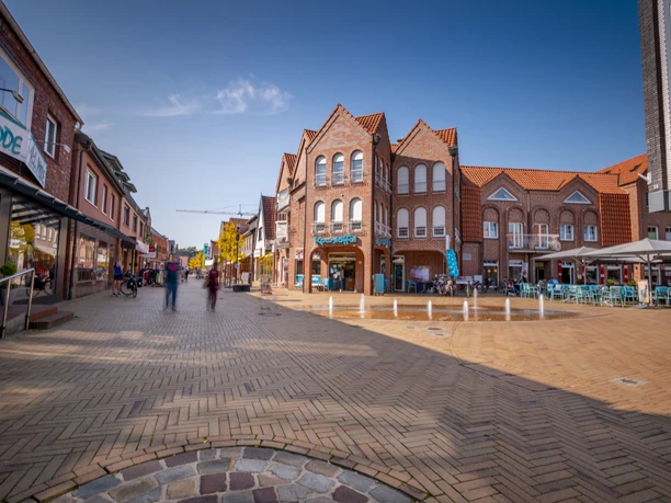 Haren (Ems) Innnenstadt Fußgängerzone in Haren mit rotem Klinker, Straßencafés, Geschäften und hellem Pflaster bei Sonnenschein.