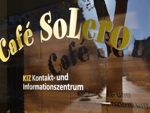 KIZ Café SoLero Bad Oeynhausen.JPG Auf dem Bild sind die Schaufenster des Cafés zu sehen, wobei der goldene Schriftzug „Café SoLero“ im Vordergrund besonders hervorsticht.