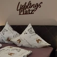 moderne_ferienwohnung_lieblingsplatz2.jpg Ein stilvoll eingerichtetes Schlafzimmer mit einem Doppelbett, dekorativen Schmetterlingskissen und sanfter Beleuchtung.