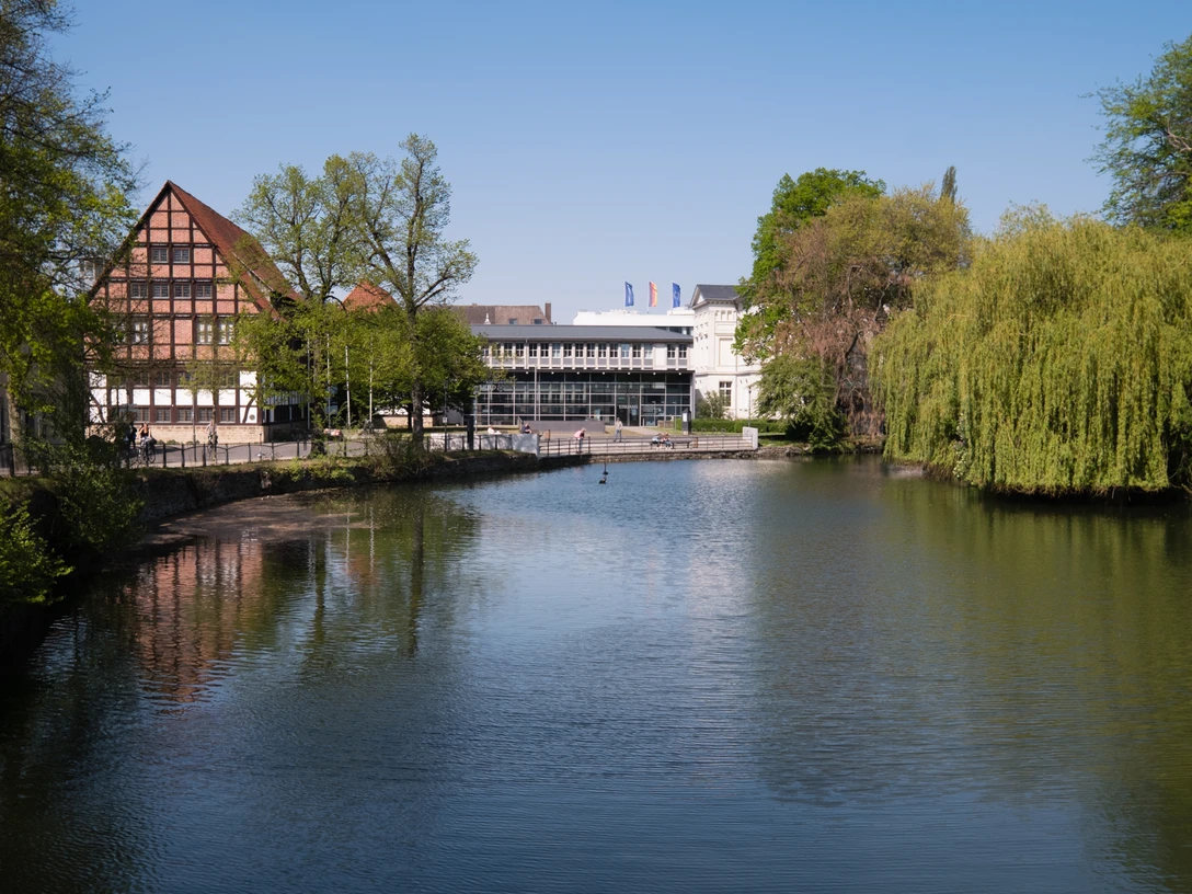 Blick auf das Lippische Landesmuseum Eine ruhige Flusslandschaft mit reflektierendem Wasser; im Hintergrund das Lippische Landesmuseum.