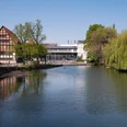 Blick auf das Lippische Landesmuseum Eine ruhige Flusslandschaft mit reflektierendem Wasser; im Hintergrund das Lippische Landesmuseum.