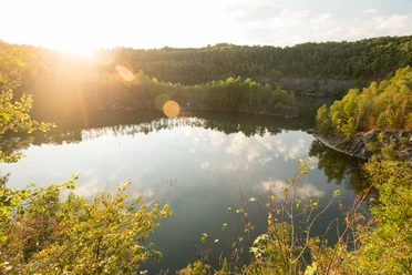 Steinbruch Schlupkothen bei Wülfrath Sonnenstrahlen über dem Steinbruch Schlupkothen spiegeln sich malerisch im ruhigen Wasser wider.