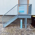 E-Bike Ladestation an der Touristikinformation Rietberg_2 Treppe mit Handlauf vor Gebäude, daneben steht eine E-Bike-Ladestation auf gepflastertem Boden.