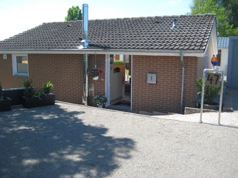 FH-Hauseingang, Parkplatz.JPG Einstöckiges Ziegelgebäude mit Flachdach, Hausnummer 47, Eingang links, Parkplatz im Vordergrund.