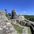 Mittelalterliche Burgruine Falkenburg auf einem Hügel, umgeben von grünen Wäldern und blauem Himmel.