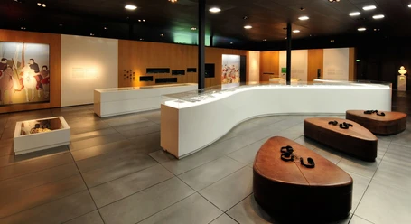 Ausstellung im Museum der BARUSSCHLACHT Moderne Museumsausstellung mit informativem Wandpanel, Glasvitrinen und bequemen Sitzgelegenheiten.