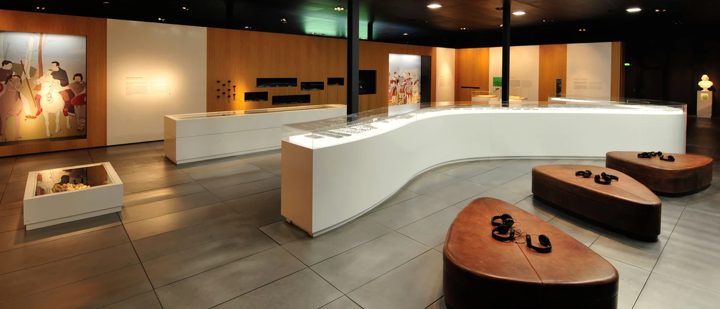 Ausstellung im Museum der BARUSSCHLACHT Modern museum exhibition with informative wall panel, glass showcases and comfortable seating.