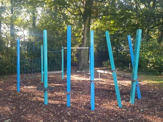 Bürgerpark-Schapen_Spielbereich_©SG-Spelle.jpg Modern gestalteter Spielbereich mit blauen Kletterelementen im schattigen Bürgerpark Schapen.
