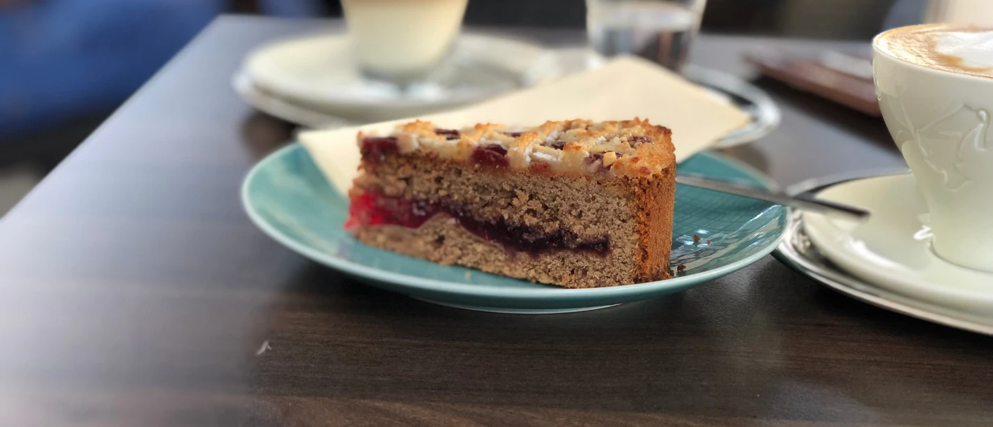 Kuchen Ein köstliches Stück Obstkuchen mit einer knusprigen Kruste liegt auf einem grünen Teller.