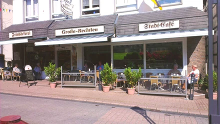 Große-Rechtien_Bad Iburg_Teutoburger Wald Tourismus_Bohlken.jpg Straßencafé mit Terrasse, Blumenschmuck und Gästen, die unter Markisen gemütlich speisen und verweilen.