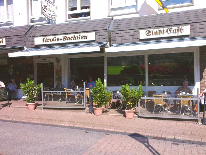 Große-Rechtien_Bad Iburg_Teutoburger Wald Tourismus_Bohlken.jpg Straßencafé mit Terrasse, Blumenschmuck und Gästen, die unter Markisen gemütlich speisen und verweilen.