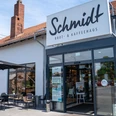 Dies ist die Außenansicht der Bäckerei Schmidt mit Sitzgelegenheiten..