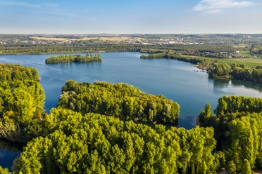 Elbsee bei Hilden Luftaufnahme des Elbsees bei Hilden, umgeben von dichten Wäldern und weitläufigen Wasserflächen.