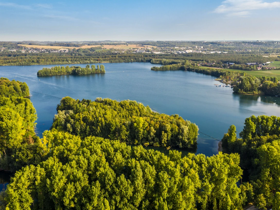 Elbsee bei Hilden Luftaufnahme des Elbsees bei Hilden, umgeben von dichten Wäldern und weitläufigen Wasserflächen.