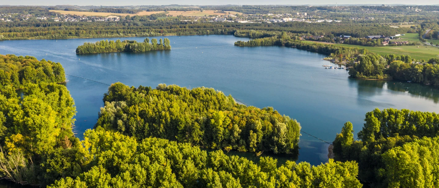 Elbsee bei Hilden Luftaufnahme des Elbsees bei Hilden, umgeben von dichten Wäldern und weitläufigen Wasserflächen.