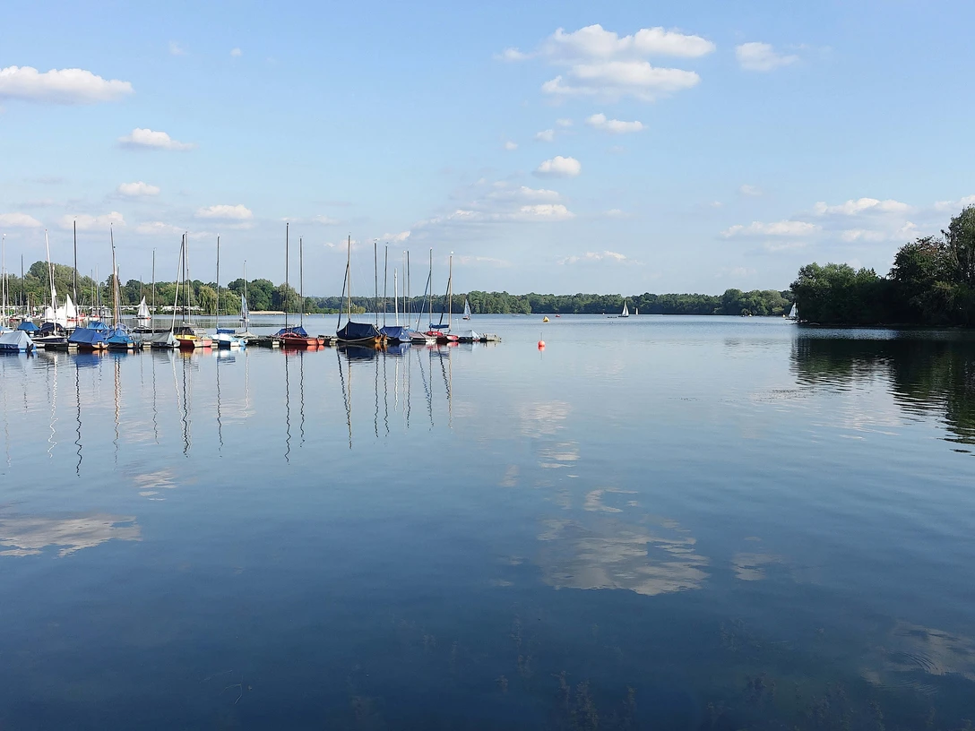 Bootshafen am Unterbacher See bei Erkrath und Hilden Boote liegen ruhig am Steg im Bootshafen des Unterbacher Sees, umgeben von ruhigem Wasser und bewaldetem Ufer.