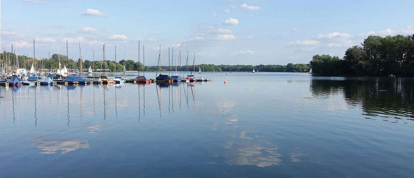 Bootshafen am Unterbacher See bei Erkrath und Hilden Boote liegen ruhig am Steg im Bootshafen des Unterbacher Sees, umgeben von ruhigem Wasser und bewaldetem Ufer.
