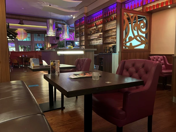 A modern café with stylish interior design, purple accents and comfortable seating.