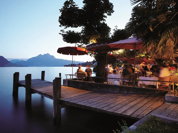 Restaurant-Pizzeria SeeHotel Gotthard Garden terrace directly on the lake at dusk