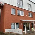 Backsteinfassade von Thöles Hotel mit großen Fenstern und einem überdachten Eingang in Vilsen.