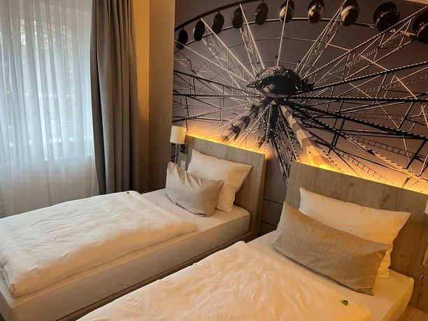 Thöles Hotel in Vilsen Zimmer im Thöles Hotel in Vilsen mit zwei Einzelbetten und großem Wandbild eines Riesenrads.