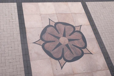 Lippische Rose hinter dem Rathaus Detmold Rosenmotiv aus dunklen Pflastersteinen auf hellem Bodenbelag vor dem Rathaus von Detmold.