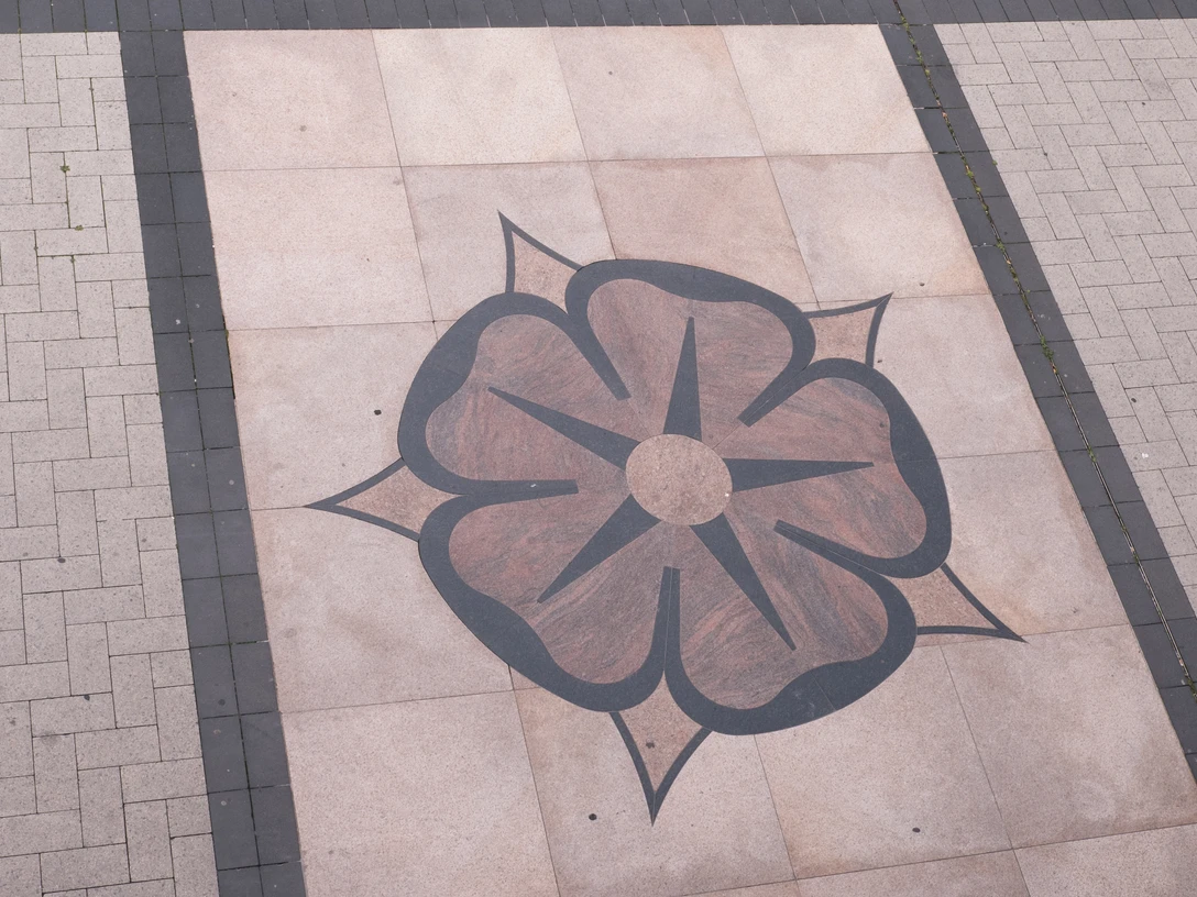Lippische Rose hinter dem Rathaus Detmold Rosenmotiv aus dunklen Pflastersteinen auf hellem Bodenbelag vor dem Rathaus von Detmold.