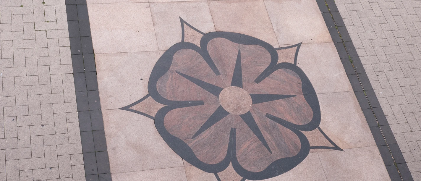 Lippische Rose hinter dem Rathaus Detmold Rosenmotiv aus dunklen Pflastersteinen auf hellem Bodenbelag vor dem Rathaus von Detmold.