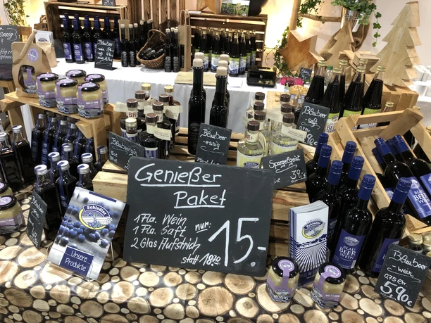 Vielfältiges Angebot an regionalen Produkten, darunter Fruchtweine, Säfte und Honig im stilvollen Präsentationsbereich.