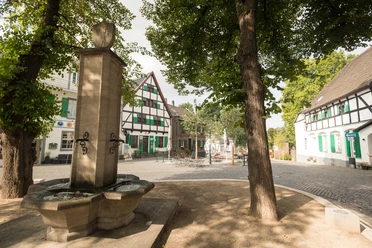 Monheimer Altstadt Historischer Marktplatz in der Monheimer Altstadt mit Fachwerkhäusern und einem steinernen Brunnen.
