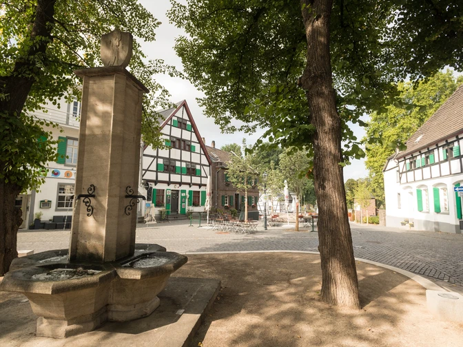 Monheimer Altstadt Historischer Marktplatz in der Monheimer Altstadt mit Fachwerkhäusern und einem steinernen Brunnen.
