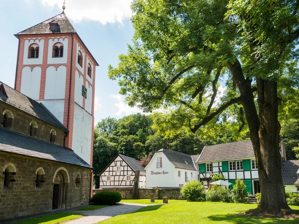Odenthal <p>Historischer Kirchplatz in Odenthal mit Fachwerkhäusern und mächtigem Baum im Sonnenschein.</p>