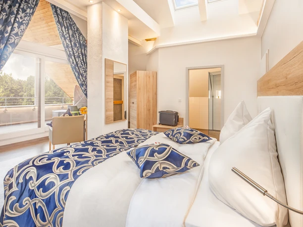 Suite Geräumige Suite mit eleganter Einrichtung, stilvollen blauen Akzenten und Zugang zu einem Balkon.