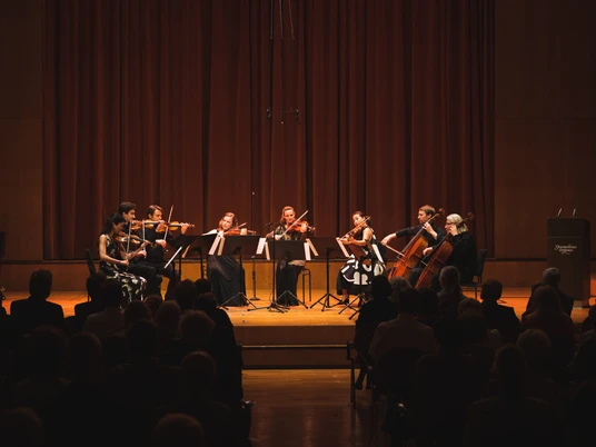 K1_GWH©Christian_Kern_L1050038.jpg Ein Streichorchester spielt auf einer Bühne vor Publikum in einem Konzertsaal.