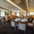 Restaurant Mauritz im Lind Hotel Ein stilvoll eingerichteter Restaurantraum mit elegant gedeckten Tischen und gemütlicher Atmosphäre.