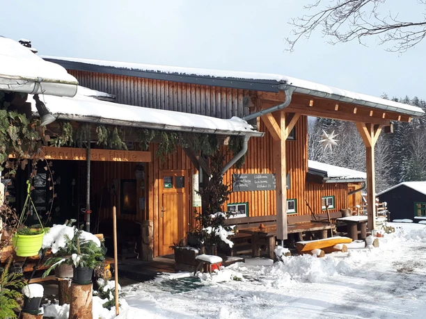 Ottendorf hut in het besneeuwde winterbos met houten hut en uitnodigende veranda.